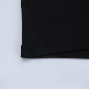 Dettaglio della cucitura a doppio ago sull'orlo dei pantaloni a zampa neri in cotone