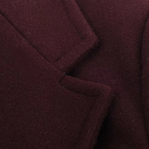 Macro shot of dark wine red wool coat collar showing texture and stitching details