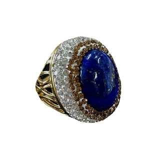 Vintage gold cocktail ring featuring a large oval blue gemstone and hollow woven band