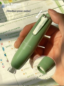 Primo piano del nastro correttore a scatto verde con dettaglio della punta e logo.