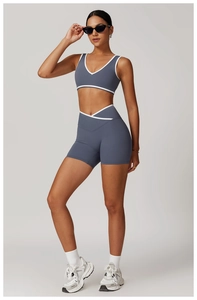 Detail of blue-grey high-waist yoga shorts with cross waistband and white contrast piping