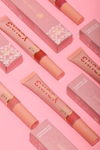 Close-up of high-shine liquid lip gloss with soft cushion-tip applicator and packaging