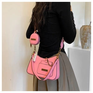 Pink PU shoulder bag detail showing the metal logo plate and matching round coin purse