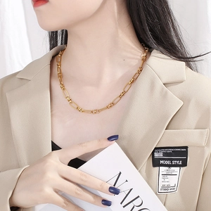 Collana a catena minimalista in acciaio dorato indossata con un blazer beige