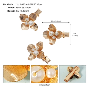 Vue détaillée de trois pinces à cheveux fleurs dorées avec perles et texture brossée