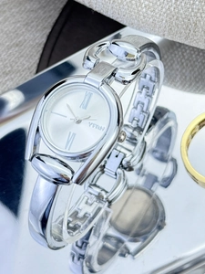 Close-up of vintage silver bracelet watch with white Roman dial on reflective surface