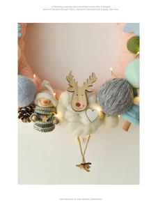 Detail of Christmas felt wreath with LED lights, wooden reindeer, and plush pom poms