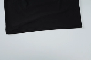 Détail de l'ourlet de la robe noire montrant une couture à double aiguille de qualité