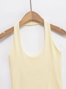 Détail du haut en tricot dos nu jaune clair montrant la texture côtelée sur un cintre