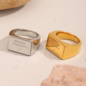 Dettaglio macro di anelli quadrati in acciaio inossidabile oro e argento con incisione