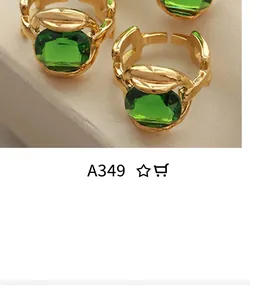 Detail of vintage gold ring with emerald green stone and chain pattern design