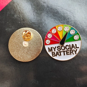 Detailed view of My Social Battery enamel pin showing sliding scale and secure backing