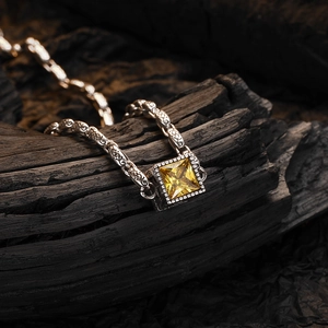 Vintage Thai silver necklace with square yellow zircon pendant on dark charcoal wood