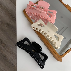 Détail des pinces à cheveux en acétate rose, beige et noir avec texte Barrette La France