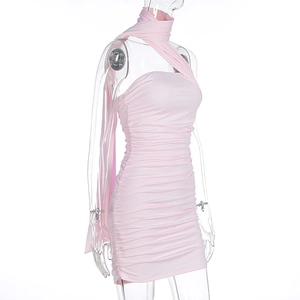 Détail de robe courte froncée rose clair avec foulard licou et texture plissée