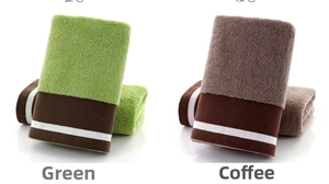 Close-up of thick cotton towel loops in green and coffee brown with white stripe detail