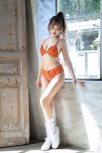 Nahaufnahme von orangem Halter-Bikini mit Rüschen und hoch taillierten Denim-Shorts