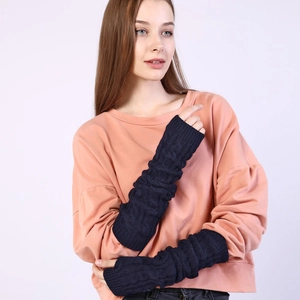 Detail of dark blue cable-knit arm warmers showing thick braided texture and long sleeve design