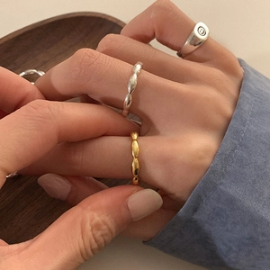 Primer plano de anillos de cuentas dorados y plateados con un anillo de carita feliz