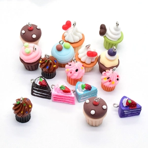 Macro shot of assorted resin mini layer cake charms with metal rings on white background