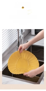 Water rinsing a yellow sunflower-shaped silicone heat-resistant placemat in a kitchen sink