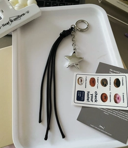 Detail of vintage Y2K silver star charm with long black tassels on a metal keychain