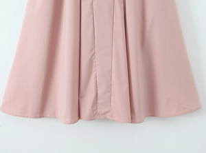 Détail de l'ourlet de robe froncé rose montrant la texture et les coutures nettes