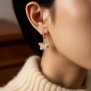Elegant gold butterfly earrings with zircon crystals shown on model for a luxury look