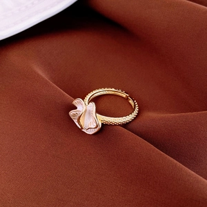 Gold plated oval ring with white pleated flower detail and caviar texture band