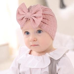 Détail du bonnet turban bébé rose clair en maille avec décoration grand nœud