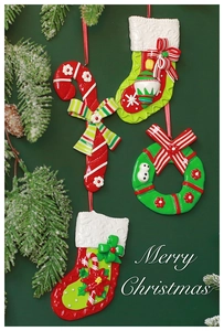 Detailed view of Christmas stocking and candy cane clay hanging ornaments with pine branches