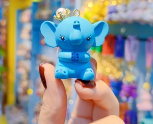 Close-up of a blue resin elephant keychain with a gold crown and pearl detail