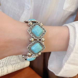 Detailed view of bohemian bracelet featuring square turquoise stones and silver-toned metal beads