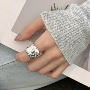 Minimalist square hammered 925 sterling silver ring shown on hand in lifestyle setting