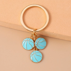 Detail of three light blue enamel basketball charms on a gold-plated keychain