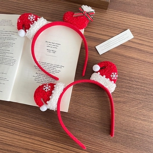 Cute Christmas headband set with red plush hats and silver snowflakes on wooden background