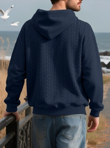 Detailed view of dark blue men's hoodie featuring an intricate cable knit textured pattern