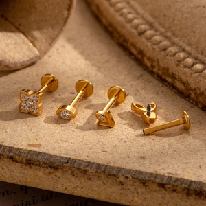 Golden G23 titanium cartilage studs set with zircon in clover and eye shapes