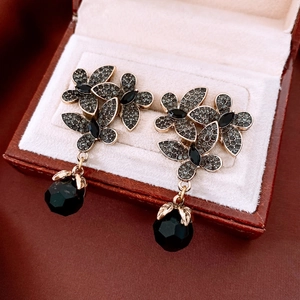 Detail of vintage flower earrings with black rhinestones and crystals in a jewelry box