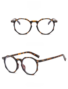 Detail view of tortoiseshell polygonal frames with blue light blocking transparent lenses