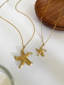Detailed macro view of 18k gold starfish pendant set with textured metal finish