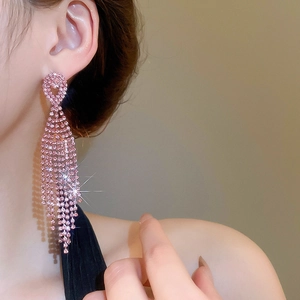 Model wearing pink rhinestone tassel earrings with a long water drop crystal design