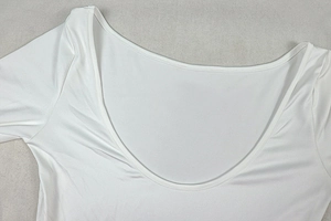Detail of the deep U-neckline and smooth fabric texture on this white long sleeve dress