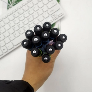 Close-up of spinning pens with colored rings and balanced metal beads on a keyboard
