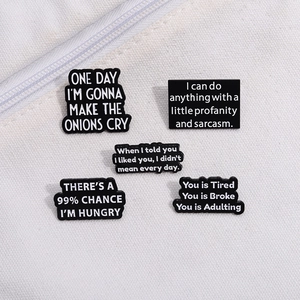Set of five black enamel pins with funny English slogans on a white textured background