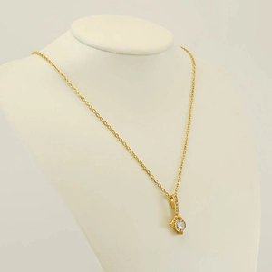 Elegant gold necklace with sparkling zircon pendant displayed on a jewelry neck bust