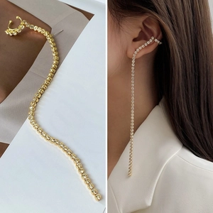 Détail du bijou d'oreille à nœud strass et pompon doré avec vue portée sur modèle