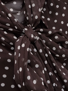 Detail of soft dark brown chiffon fabric with white polka dots and a bow tie knot