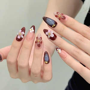 Elegant almond-shaped press-on nails featuring 3D floral carvings and a glossy cat-eye effect