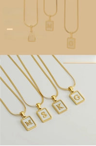 Detailed view of 18K gold-plated square pendants with natural shell inlay and letters
